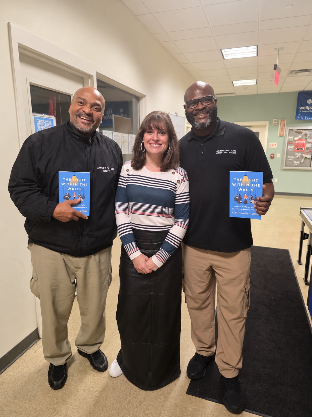 C.P. Handler with juvenile detention center staff holding copies of the book